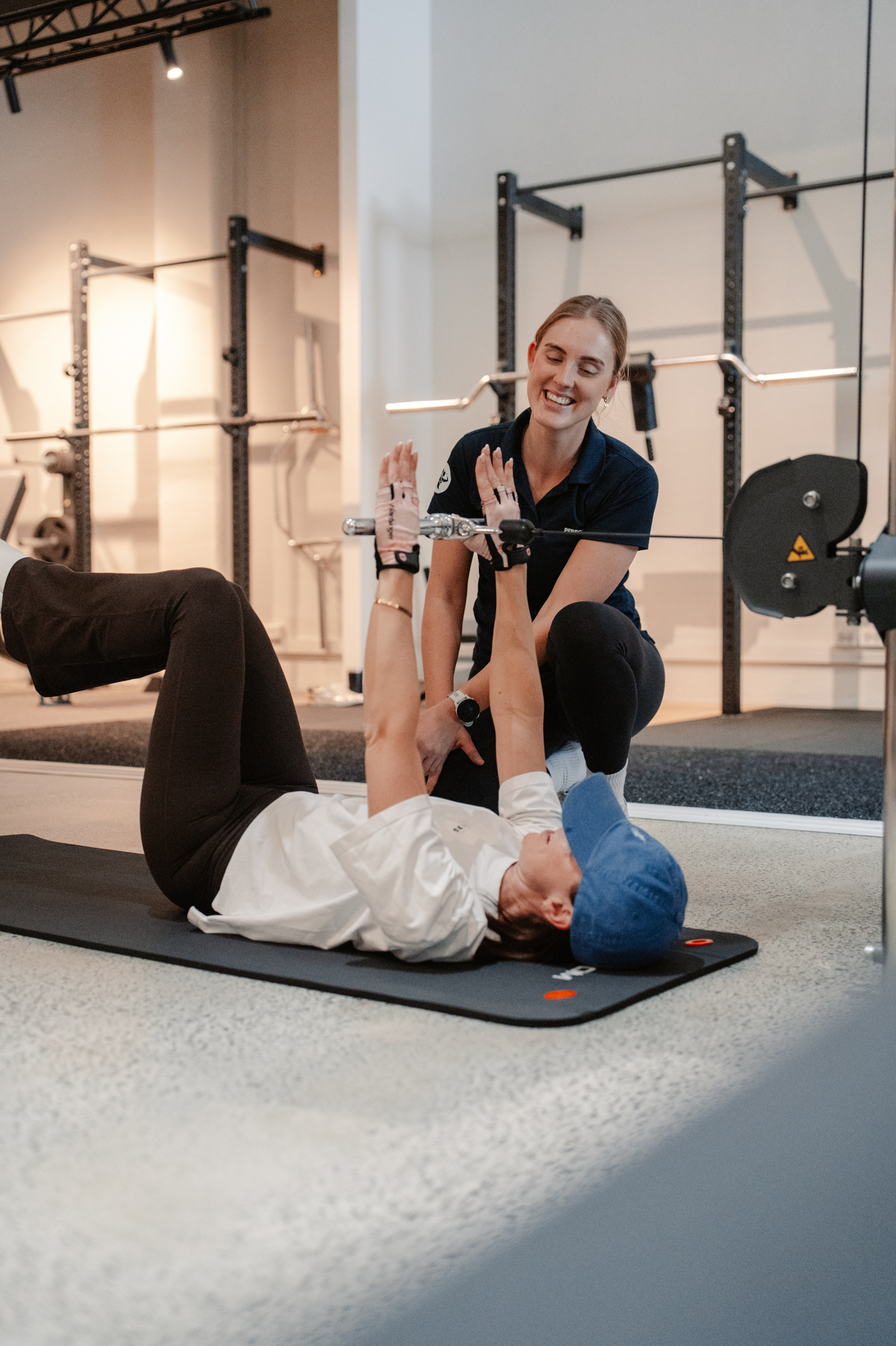 An Exercise Physiologist coaching a member through a floor exercise at PerforMotion