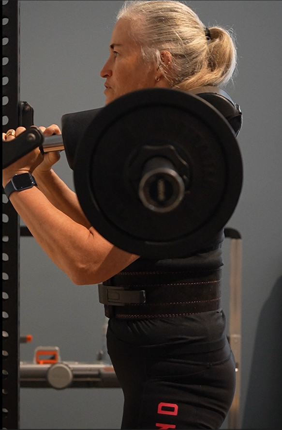 Member training independently on the open gym floor at PerforMotion
